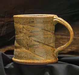 Mustard-glazed stoneware mug with carved motif