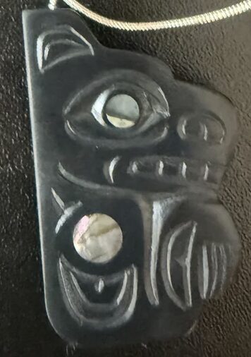Carved argillite pendant with abalone inlay